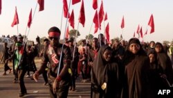Shi'ite Muslims march during the 40th anniversary of the Ashura religious ceremony in the village of Dakasoye, northern Nigeria, following a suicide bombing attack that killed at least 21 people near Kano, Nov, 27, 2015.