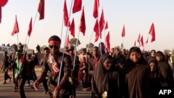 Shiite Muslims march during the 40th anniversary of the Ashura religious ceremony in the village of Dakasoye, northern Nigeria, following a suicide bombing attack that killed at least 21 people near Kano, Nov, 27, 2015.