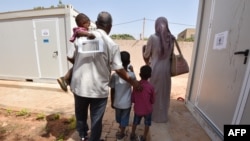 Des réfugiés marchent près des bâtiments de l'UNHCR à Niamey, après avoir été évacué de la Libye, le 17 novembre 2017.