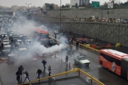 FILE - Riot police disperse protesters as they rally on a highway against increased fuel prices in Tehran, Iran, Nov. 16, 2019.