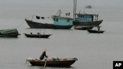 Vietnamese boatman rows past fishing boats, Ha Long Bay, northeast of Hanoi, Vietnam. (AP)