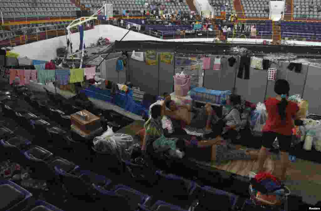 Families take refuge in an indoor basketball stadium at the Tacloban City Convention Center, which has become a homeless shelter after the super typhoon Haiyan battered the area, Nov. 12, 2013. 