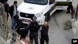 Israeli border policemen arrest the brother and father, right, of Palestinian Moatez Higazi after he was shot in east Jerusalem, Oct. 30, 2014. 