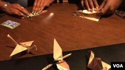 Mya Brown and Dominic Green participate in the 2,300 paper cranes folding event​ at Radical Library inside Eaton DC, Washington DC, on November 18, 2018. (Say Mony/VOA Khmer) 