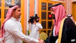 In this photo released by Saudi Press Agency, SPA, Saudi Crown Prince Mohammed bin Salman, right, shakes hands with Salah Khashoggi, son of Jamal Khashoggi, in Riyadh, Saudi Arabia, Oct. 23, 2018. Salah Khashoggi has arrived in the United States after Saudi restrictions on his passport were lifted. 