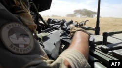 FILE - A soldier of France's Barkhane mission holds a weapon as he patrols in central Mali, in the border zone with Burkina Faso and Niger, Nov. 01, 2017. 