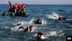 Des migrants finissent leur parcours à la nage après que leur bateau se soit renversé près de l'île de Lesbos, Grèce, le 20 septembre 2015. 