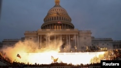 An explosion caused by a police munition is seen while supporters of U.S. President Donald Trump gather in front of the U.S. Capitol Building in Washington, Jan. 6, 2021. 