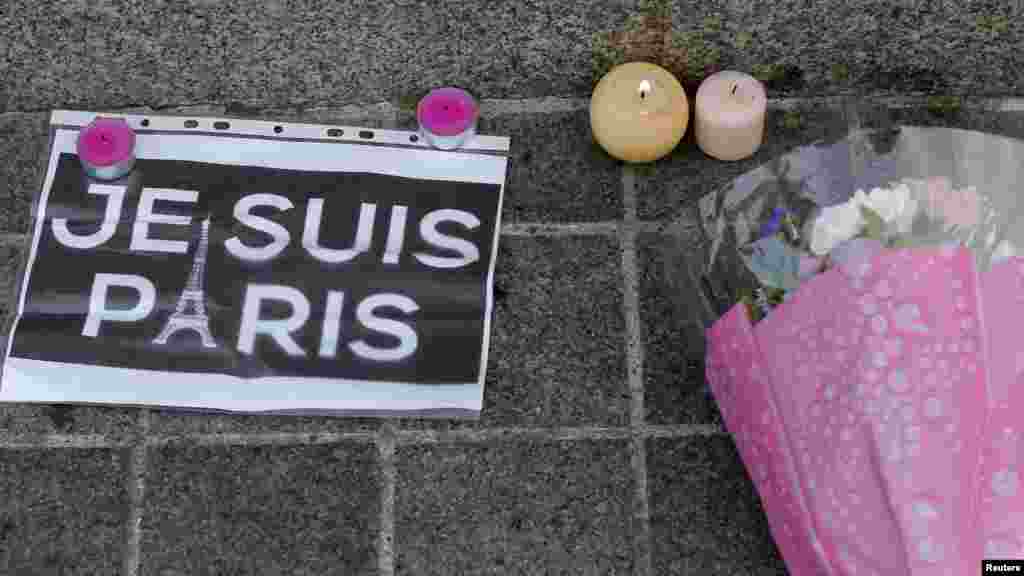 Candles, flowers and a leaflet with the slogan "I am Paris" are left in tribute to victims of Paris attacks in central Strasbourg, France, Nov. 14, 2015. 