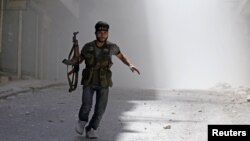 A Free Syrian Army fighter runs after a Syrian Army tank shell explodes in the Salah al- Din neighbourhood of central Aleppo, August 5, 2012.