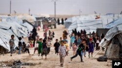 Des enfants au camp d'al-Hol, qui abrite des familles de membres du groupe État islamique, dans la province de Hasakeh, en Syrie, le samedi 1er mai 2021. (Photo AP/Baderkhan Ahmad)