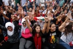 FILE - Anti-government protesters shout slogans as they block a main highway, in Beirut, Lebanon, Oct. 26, 2019.