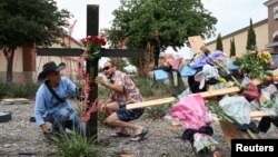 Muralist Roberto Marquez and his friend Israel Gil from Dallas erect a memorial on May 7, 2023 to honor those who lost their lives when a gunman shot multiple people at the Dallas-area Allen Premium Outlets mall in Allen, Texas.