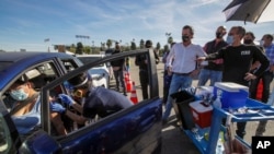 In this Jan. 15, 2021, file photo, Los Angeles Mayor Eric Garcetti, right, and Governor Gavin Newsom tour the mass COVID-19 vaccination site at Dodger Stadium in Los Angeles.