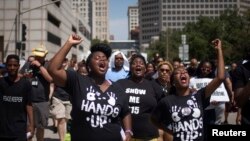 Activists raise their hands as they demand justice for the killing of Michael Brown while marching to the Thomas F. Eagleton United States Courthouse from City Hall in downtown St. Louis, Missouri, Aug. 26, 2014. 