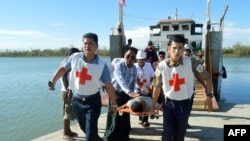 FILE - Injured people from Kyauk Tan village in Rathedaung township are carried on stretchers as they arrive in Rakhine state's capital Sittwe in western Myanmar, May 2, 2019.