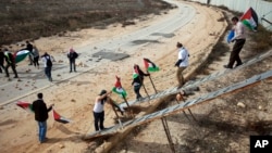 Palestinian activists use ladders to cross over the Israeli separation barrier to pray on Friday at the al-Aqsa Mosque in the Old City of Jerusalem, Nov. 14, 2014. 