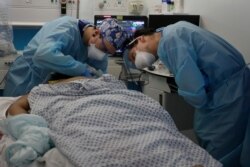 FILE - Critical care staff look after a COVID-19 patient on the Christine Brown ward at King's College Hospital in London, Jan. 27, 2021.
