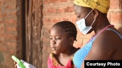 A student works with her mother on a lessons using a tablet provided by British charity Voluntary Services Overseas, in Malawi. (Photo courtesy of VSO/Craig Mawanga)