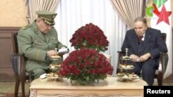 FILE - Algeria's President Abdelaziz Bouteflika, right, meets with Army Chief of Staff Lieutenant General Ahmed Gaid Salah in Algiers, Algeria, in this handout still image taken from a TV footage released on March 11, 2019. 