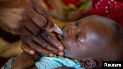 FILE - A child receives an oral Malaria vaccine at Chileka Health Center, in Lilongwe, Malawi in this undated handout photo from UNICEF.