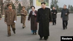 A man takes a picture of portraits (LtoR) of late French satirical weekly Charlie Hebdo's deputy chief editor Bernard Maris, French cartoonists Georges Wolinski, Bernard Verlhac (aka Tignous), Charlie Hebdo editor Stephane Charbonnier (aka Charb) and Jean Cabut (aka Cabu) near the magazine's offices at Rue Nicolas Appert, in Paris on the third anniversary of the jihadist attack on French satirical magazine <em>Charlie Hebdo</em>.