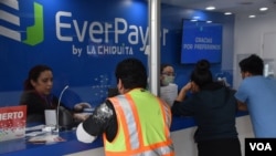 El insólito aumento de envío de remesas al Triángulo Norte de Centroamérica ha sorprendido a los expertos por el aumento exponencial de las cifras. En la imagen trabajadores en una casa de envío de remesas en Maryland al principio de la pandemia.