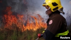 A firefighter monitors a spot fire in an area of the Amazon rainforest, near Porto Velho, Rondonia State, Brazil August 16, 2020. (REUTERS/Ueslei Marcelino)