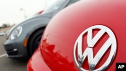 FILE - The Volkswagen logo on the hood of a 2012 Beetle at a Volkswagen dealership.