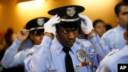 FILE - An LAPD Cadet Commander adjusts his hat before the LAPD Cadet Program Graduation of the cadet "Class of 7-2014".