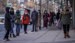 People wait on a line stretching around a block, outside a CityMD urgent care clinic offering COVID-19 testing, Nov. 18, 2020, in the Park Slope area of the Brooklyn borough of New York.