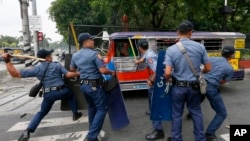 Police officers hit fleeing protesters during a violent dispersal outside the U.S. Embassy in Manila, Philippines, Oct. 19, 2016.