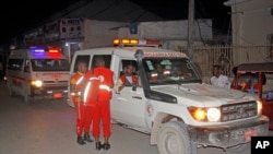 Medical workers wait by ambulances ready to transport wounded, after a bomb attack at an ice cream shop in Mogadishu, Somalia, Nov. 27, 2020