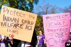 FILE - Demonstrators stand outside of the U.S. Supreme Court, as the court hears arguments over the Indian Child Welfare Act, Wednesday, Nov. 9, 2022, in Washington.