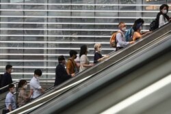 People wearing face masks to help protect against the spread of the coronavirus ride an escalator as they arrive at the Seoul Railway Station in Seoul, South Korea, Aug. 24, 2020.