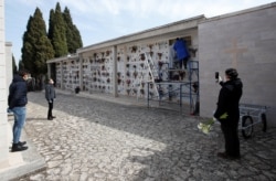 Relatives attend a burial ceremony of victims of coronavirus disease (COVID-19) in the southern town of Cisternino, Italy, March 30, 2020.