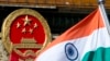 An Indian national flag is flown next to the Chinese national emblem (AP/Andy Wong)
