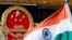 An Indian national flag is flown next to the Chinese national emblem (AP/Andy Wong)