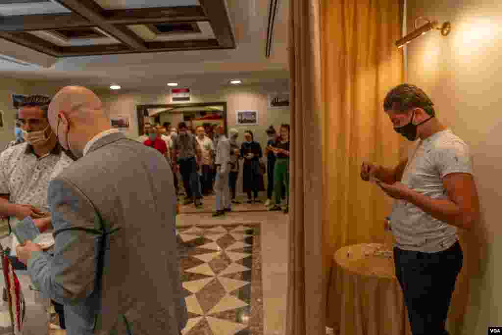 Voters choose their candidate behind curtains to ensure privacy, but many see this vote as symbolic and not as an exercise in electoral freedom. (H. Elrasam/VOA)