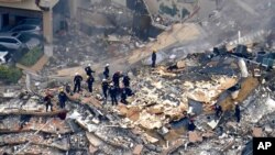 Rescue workers search in the rubble at the Champlain Towers South Condo, in Surfside, Fla., June 25, 2021.