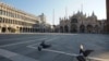 Burung merpati di lapang Santo Markus yang lengang di Venesia, Italia setelah penerapan aturan tinggal di rumah untuk mencegah penularan Covid-19, 6 April 2020.