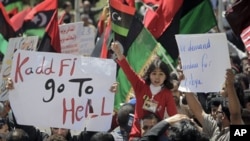 A young girl waves the opposition flag as an angry but peaceful crowd demonstrates outside the Tibesty Hotel where an African Union delegation was meeting with opposition leaders in Benghazi, Libya, April 11, 2011