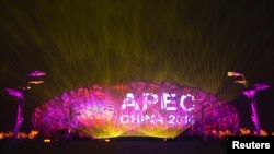 A screen displays the APEC logo on the National Stadium during a lights-and-fireworks rehearsal for the upcoming APEC Summit in Beijing, Nov. 4, 2014. 