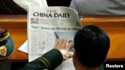 A military delegate reads a China Daily newspaper ahead of the second plenary session of the National People's Congress (NPC) in Beijing March 9, 2009. REUTERS/David Gray (CHINA POLITICS SOCIETY IMAGE OF THE DAY TOP PICTURE)