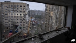 Nhân viên cứu hộ dọn dẹp đống đổ nát tại một tòa nhà chung cư đã bị phá hủy trong một cuộc tấn công bằng phi đạn của Nga vào một khu dân cư ở thành phố Dnipro, đông nam Ukraine, ngày 16 tháng 1 năm 2023.