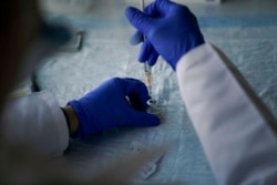 Nurse practitioner Christie Aiello prepares the Pfizer-BioNTech COVID-19 vaccine for medical workers at St. Joseph Hospital in Orange, Calif., Jan. 7, 2021.