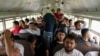 Sejumlah migran asal Honduras yang baru saja dideportasi dari Amerika Serikat duduk di dalam sebuah bus setelah tiba di Bandara Ramon Villeda Morales di San Pedro, Honduras, pada 4 Desember 2024. (Foto: AP/Moises Castillo)