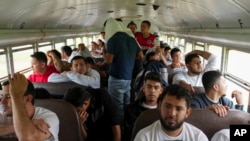 Sejumlah migran asal Honduras yang baru saja dideportasi dari Amerika Serikat duduk di dalam sebuah bus setelah tiba di Bandara Ramon Villeda Morales di San Pedro, Honduras, pada 4 Desember 2024. (Foto: AP/Moises Castillo)