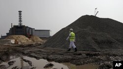 A plant worker walks by construction site in Chernobyl, (VOA - D. Markosian, April 2011)