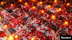FILE - Flowers are seen near photos of protesters who died during a protest against the military coup Myanmar, outside the ASEAN building in Jakarta, Indonesia, March 12, 2021. 